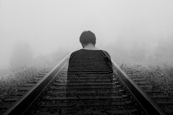 A silhouette of a man on a train track