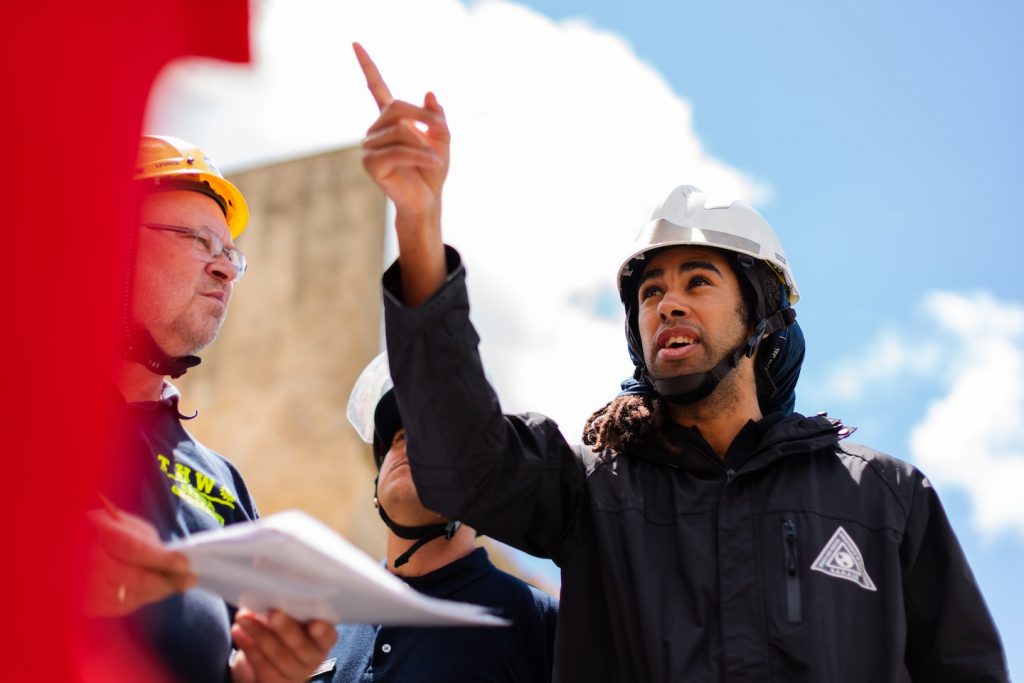 engineer wearing hardhat and pointing