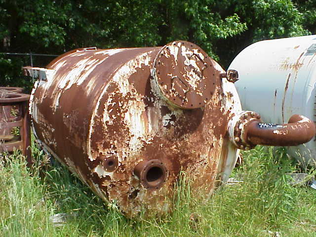 rusted pressure vessel in a field