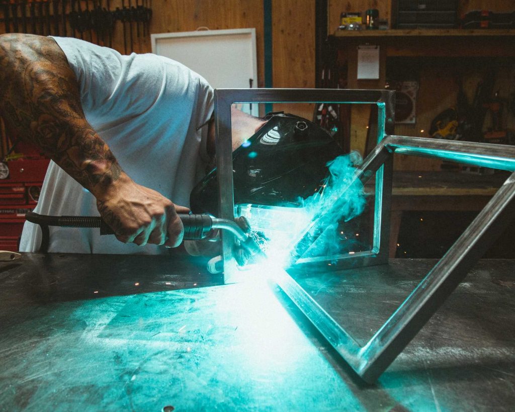 A man fabricating a steel frame